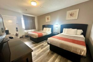 2 double beds, night stand with telephone, art images, wall light, unit with TV, desk with chair, laminate flooring