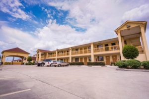 Exterior of hotel showing parking lot and outside room entrances