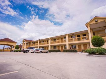 Exterior of hotel showing parking lot and outside room entrances