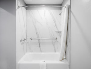 Shower tub with grab handles, shower curtain and bathmat