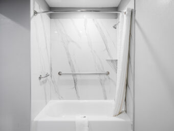 Shower tub with grab handles, shower curtain and bathmat