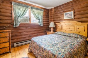 Wooden drawer unit, queen bed , night stands with lamp, wall mounted art and wooden floor