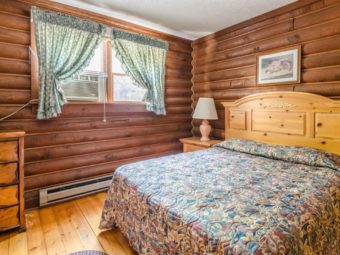 Wooden drawer unit, queen bed , night stands with lamp, wall mounted art and wooden floor