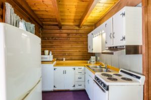 Fridge freezer, wall and base cabinets, microwavem coffee maker, double sink , stove and carpet flooring