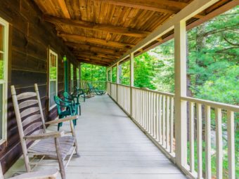 Wooden porch with wooden fencing, rocking chairs and patio furniture