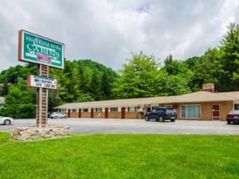 Motel exterior showing signage, motel rooms and parking area