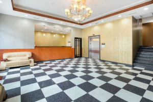 Guest check in desk, sofa, elevator, stairs, tiled flooring