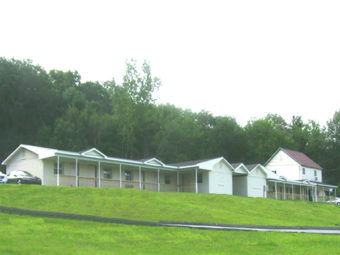 room entrances overlooking grassy area and surrounded by tall trees