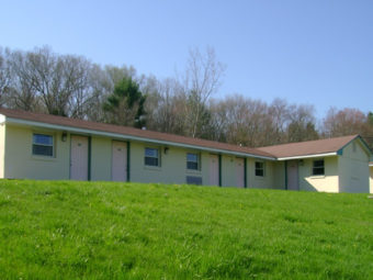 Entrance to rooms overlooking grassy area and surrounded by trees