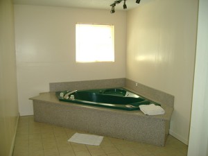 jacuzzi with bath mat, towels and tiled floor