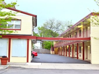 Two Two sory buildings with exterior walkways, connecting canopy, parking spaces