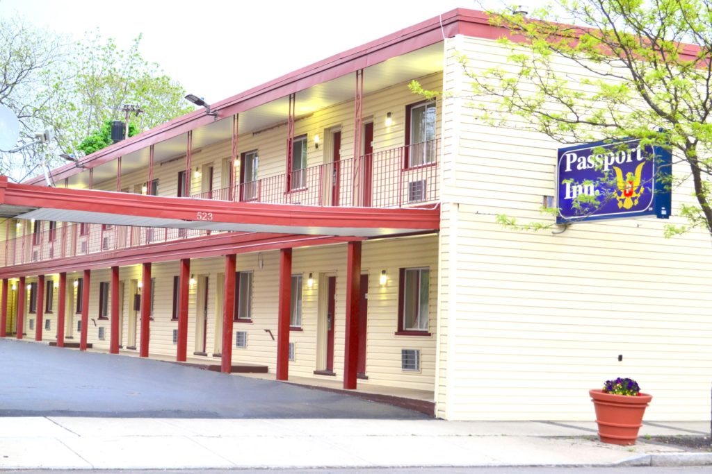 Two sory building with exterior walkways, parking spaces