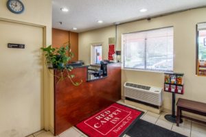 Front desk reception, candy dispensers, coffee table, clock and tiled flooring