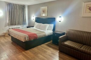 King bed, night stands, wall lights, art images, sofa, laminate flooring