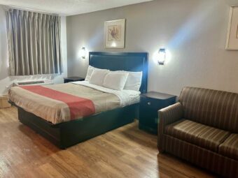 King bed, night stands, wall lights, art images, sofa, laminate flooring