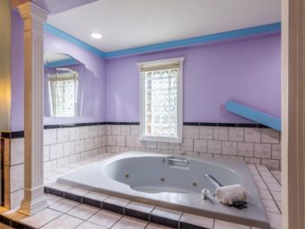 Jacuzzi, tiled surround, large decorive wall mounted mirror and greek style pillars