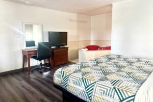 King bed, desk with chair, mirror, drawer unit with TV