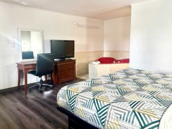 King bed, desk with chair, mirror, drawer unit with TV