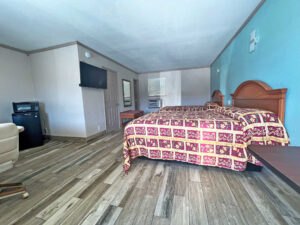 Two queen beds, mirror, stool, wall mounted TV, fridge with microwave, laminate flooring