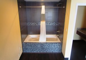 Shower tub with shower curtain, doorway leading to vanity unit