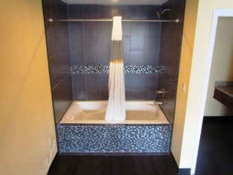 Shower tub with shower curtain, doorway leading to vanity unit