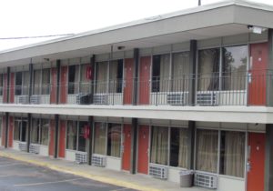 Two storey building showing exterior room entrances and walkways and parking spaces