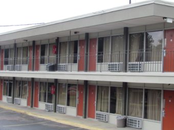 Two storey building showing exterior room entrances and walkways and parking spaces