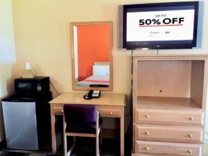 Fridge, microwave with ice bucket, desk with chair and telephone, wall mounted mirror, wooden tv console unit, wall mounted flat screen tv