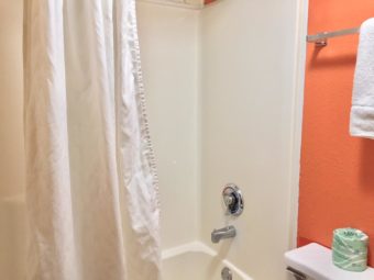 Shower tub with shower curtain, wall mounted towel rail with towel