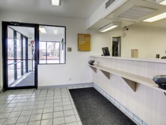 Guest check in desk, door to lobby with vending machines, tiled flooring