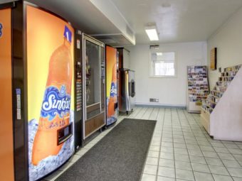 Vending snack machines, self dispensing ice machine, guest information leaflet stand, small table with microwave, tiled flooring