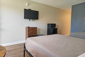 Two double beds, wooden drawer unit, wall mounted TV, fridge with microwave, laminate flooring