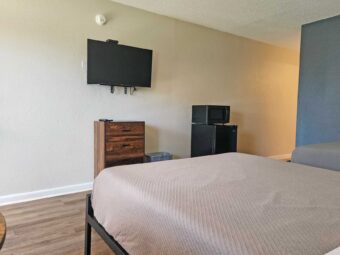 Two double beds, wooden drawer unit, wall mounted TV, fridge with microwave, laminate flooring