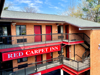 Two story building with exterior room entrances, covered walkways and stairs