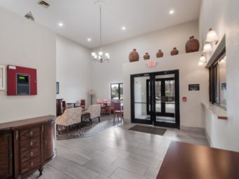 Lobby with Front Desk for check in, Tiled floor, wooden cabinet, decorative large Vases, easy chairs, floor lamp, tiled and carpet flooring and tables and chairs