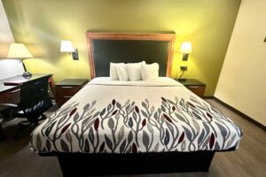 King bed, night stands, bedside lights, desk with lamp and chair, laminate flooring