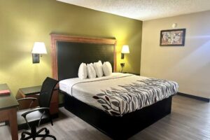 King bed, night stands, bedside wall lights, desk with chair, laminate flooring