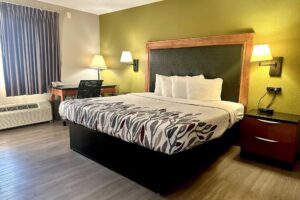 King bed, night stands with telephone, wall bedside lights, desk with telephone and lamp, laminate flooring