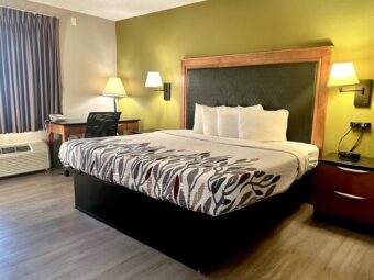 King bed, night stands with telephone, wall bedside lights, desk with telephone and lamp, laminate flooring