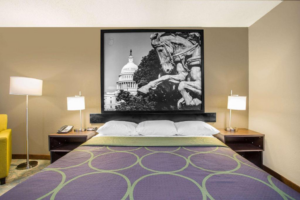 King bed, night stands with bedside lamps, telephone and clock, floor lamp, easy chair