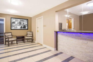 Guest check in desk, easy chairs, art image, occasional table, tiled flooring