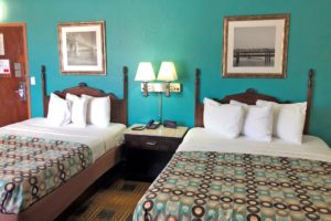 Two queen beds, night stand with telephone, wall mounted bedside lights, wall mounted art, carpet flooring