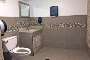 Toilet, sink, mirror and tiled floor