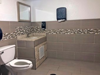 Toilet, sink, mirror and tiled floor