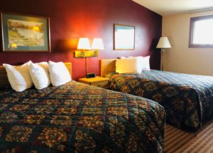 Two queen beds, wall mounted art, night stand with clock, wall mounted bedside lights and carpet flooring