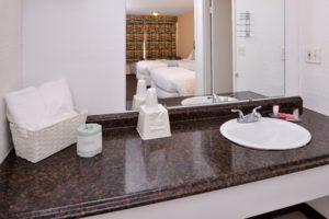 Vanity unit with sink, basket with towels, ice bucket, disposable cups and bathroom amenities