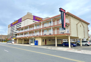 Two story building with exterior room entrances and covered walkways, vending machine and parking spaces