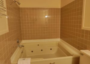 Spa tub with bath mat, tiled walls, wall mounted towel rack