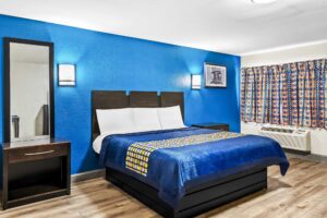 King bed, night stands, mirror, art image, wall bedside lights, laminate flooring