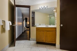 Doorway to corridor, vanity unit, mirror, towel rail with towels